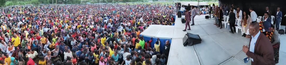 A packed crowd stretching to the horizon at an evening crusade