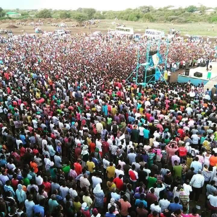 Aerial view of thousands gathered around a crusade stage